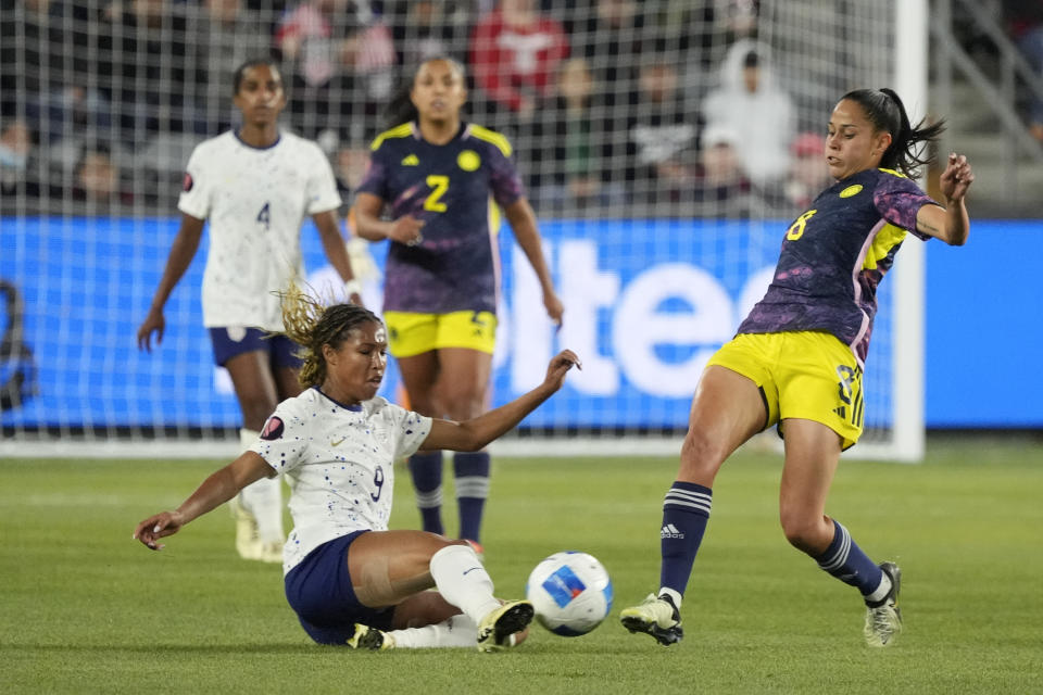 United States forward Midge Purce, left, makes a slide tackle next to Colombia midfielder Marcela Restrepo during the second half of a CONCACAF Gold Cup women's soccer tournament quarterfinal, Sunday, March 3, 2024, in Los Angeles. (AP Photo/Marcio Jose Sanchez)