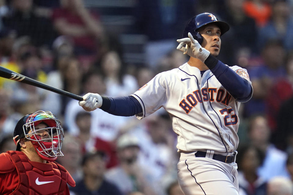 Houston Astros' Michael Brantley watches his two-run home run next to Boston Red Sox catcher Kevin Plawecki during the second inning of a baseball game at Fenway Park, Tuesday, May 17, 2022, in Boston. (AP Photo/Charles Krupa)