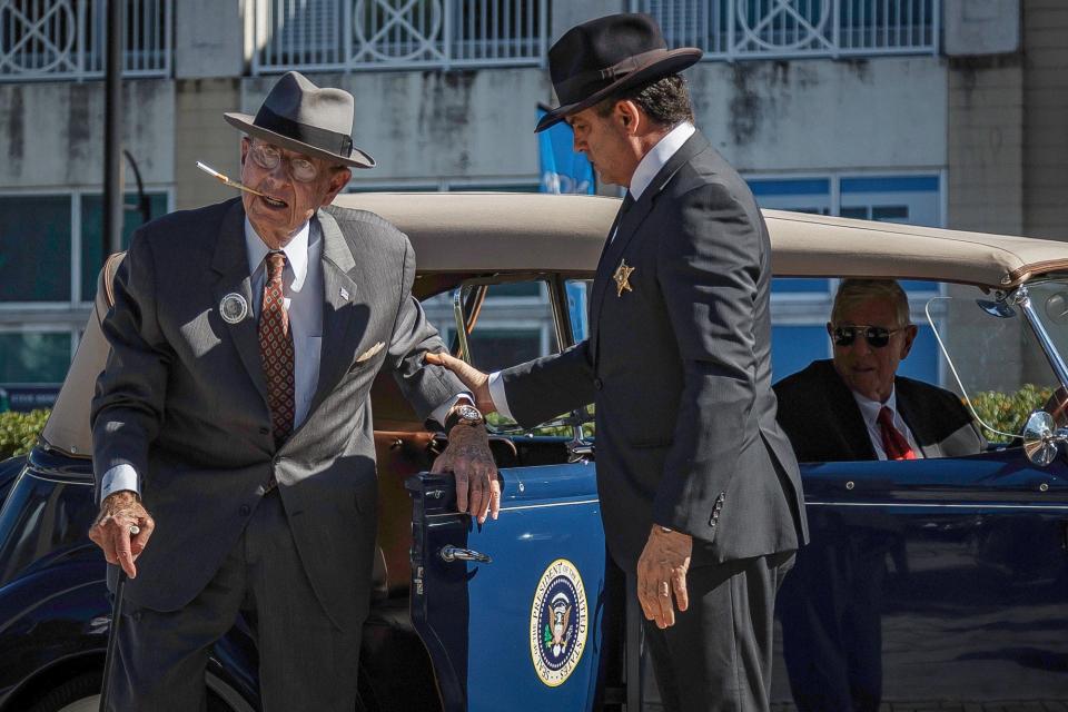Delmas P. Wood, Jr., impersonating former President Franklin D. Roosevelt, left, of Boynton Beach, exits his car with Chris Salamone, impersonating a Secret Service officer, right, of Delray Beach during the Pearl Harbor remembrance and monument dedication at Veterans Memorial Park Tuesday in Boynton Beach. This year marks the 80th anniversary of the Japanese attack.