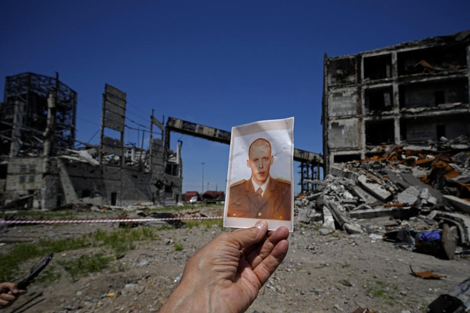 A journalist holds up a photograph of a Ukrainian serviceman found in the ruins of the Metallurgical Combine Azovstal, in Mariupol, in the territory which is under the control of the Government of the Donetsk People's Republic, eastern Ukraine, Monday, June 13, 2022. This photo was taken during a trip organized by the Russian Ministry of Defense. (AP Photo)