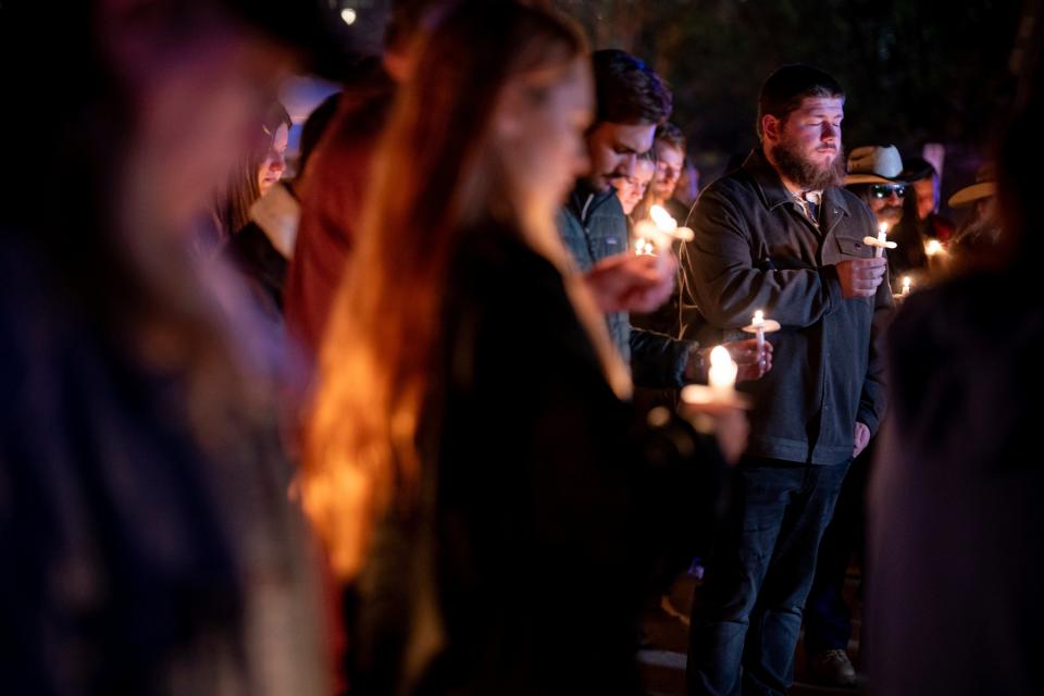 People gather and hold candles at a vigil for Riley Strain just hours after police announced his body was recovered (AP)
