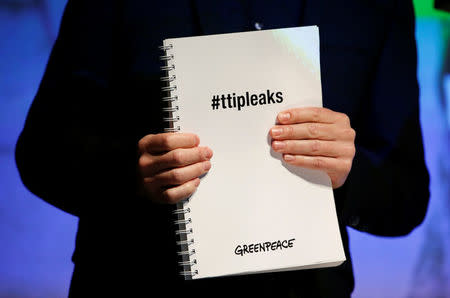 A member of the environmental campaign group Greenpeace holds a copy of the leaked TTIP negotiations during a news conference outlining its analysis of TTIP negotiations in Berlin, Germany, May 2, 2016. REUTERS/Fabrizio Bensch