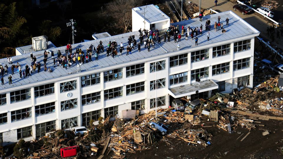 People evacuate to the roof of an elementary school after a tsunami warning was announced on March 13, 2011 in Higashimatsushima, Miyagi, Japan.  - Asahi Shimbun/Getty Images