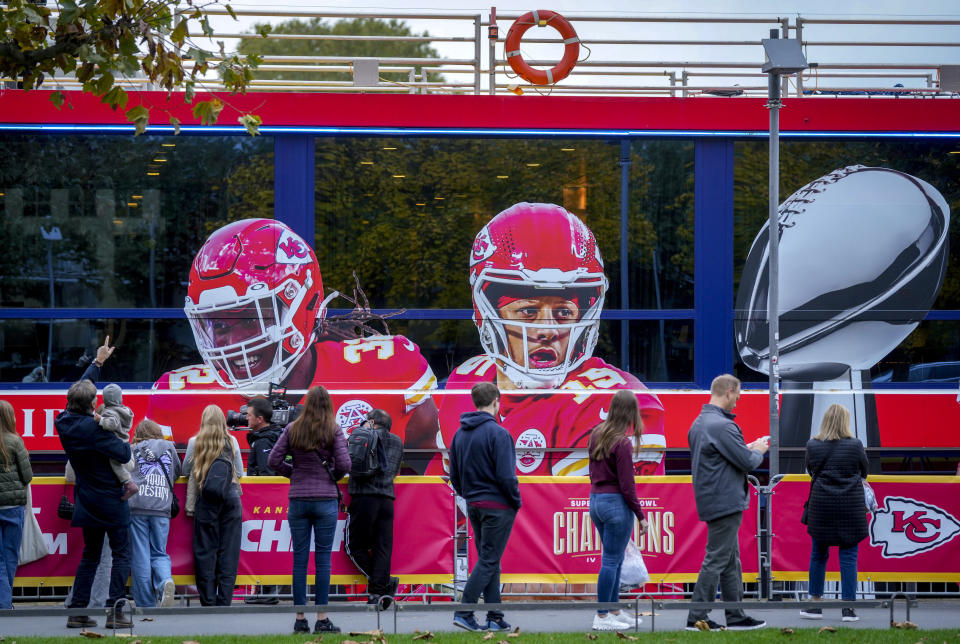 People look at a ship with the picture of Kansas City Chiefs quarterback Patrick Mahomes, right, that docked in Frankfurt, Germany, Wednesday, Nov. 1, 2023. The Miami Dolphins are set to play the Kansas City Chiefs in an NFL game in Frankfurt on Sunday Nov. 5. The ship was chartered by the chiefs. (AP Photo/Michael Probst)