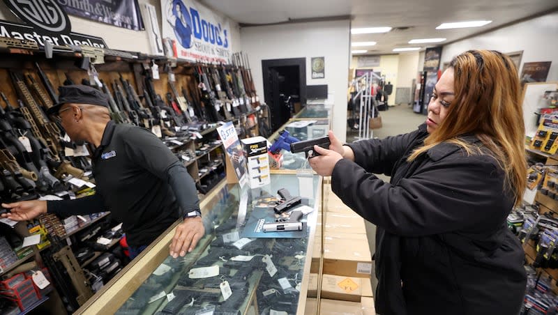 Burgess Griffin, Doug’s Shoot’n Sports salesperson, helps Tea Olive as she shops for a handgun at Doug’s Shoot’n Sports in Taylorsville on Thursday, March 7, 2024.