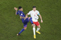 Argentina's Cristian Romero, left, challenges for the ball with Poland's Robert Lewandowski during the World Cup group C soccer match between Poland and Argentina at the Stadium 974 in Doha, Qatar, Wednesday, Nov. 30, 2022. (AP Photo/Pavel Golovkin)