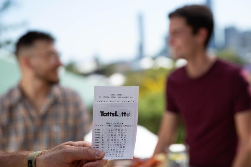 Two young men celebrate TattsLotto win on a rooftop. Source: The Lott