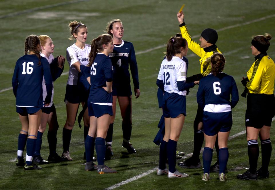 Burlington High School girls soccer players react to receiving yellow cards during Friday night's game against South Burlington at Buck Hard Field.