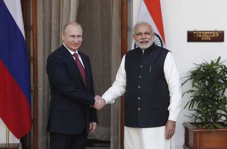 Russian President Vladimir Putin (L) shakes hands with India's Prime Minister Narendra Modi during a photo opportunity ahead of their meeting at Hyderabad House in New Delhi December 11, 2014. REUTERS/Adnan Abidi