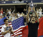 FILE - In this Sept. 9, 2007, file photo, Novak Djokovic, left, of Serbia applauds as Roger Federer of Switzerland holds up the championship trophy after winning the men's finals at the U.S. Open tennis tournament in New York. Federer is sure that Djokovic and Rafael Nadal will surpass his men's record for most Grand Slam titles, and he's ok with that. (AP Photo/Elise Amendola, File)