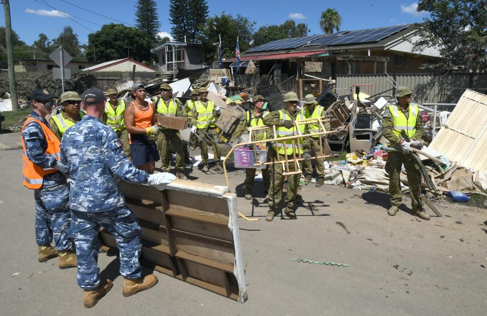 The Australian Defence Force helped local residents clean up flood-damaged properties in the suburb of Goodna in Ipswich. This photo was taken on Tuesday, March 8, 2022. <a href="https://photos.aap.com.au/search/ipswich%20flood?q=%7B%22pageSize%22:25,%22pageNumber%22:2%7D" rel="nofollow noopener" target="_blank" data-ylk="slk:Darren England/AAP;elm:context_link;itc:0;sec:content-canvas" class="link ">Darren England/AAP</a>