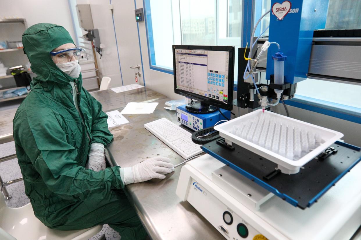 An employee wearing protective suit works at the Skolkovo biotech lab in Moscow, Russia, Tuesday, April 7, 2020. The lab said it has launched production of express tests for the new coronavirus. The new coronavirus causes mild or moderate symptoms for most people, but for some, especially older adults and people with existing health problems, it can cause more severe illness or death. (Kirill Zykov, Moscow News Agency photo via AP)