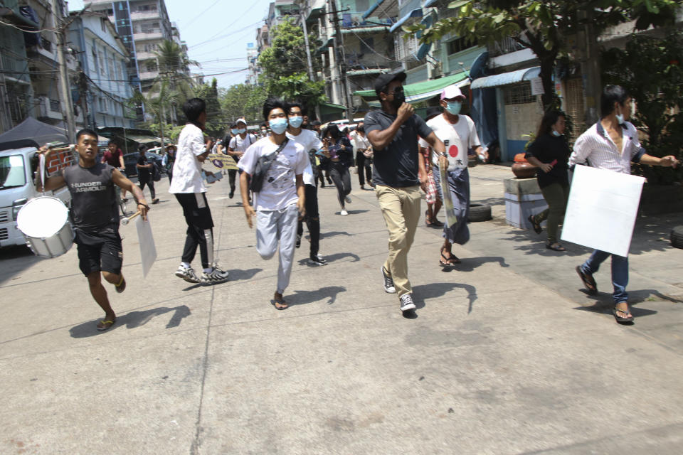 Anti-coup protesters run to avoid military forces during a demonstration in Yangon, Myanmar on Wednesday March 31, 2021. The Southeast Asian nation has been wracked by violence since the military ousted a civilian-led government on Feb. 1 and began to forcibly put down protests. (AP Photo)