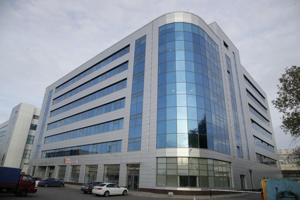 a seven-story office building with gray walls and blue windows