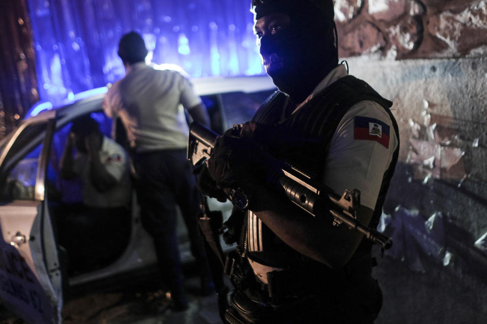 A police officer stands at an intersection in Port-au-Prince, Haiti, late Wednesday, July 14, 2021. Haiti is in the midst of a heightened security situation after the July 7 assassination of President Jovenel Moise. (AP Photo/Matias Delacroix)