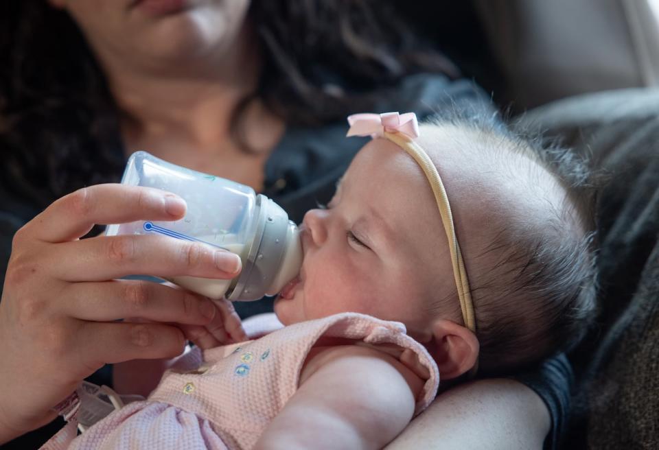 Shadia Foster feeds her three-month-old daughter, Lila, with formula. Foster says it has been a struggle to find cheaper options in stock, especially since having her first child four years ago. (Robert Short/CBC - image credit)