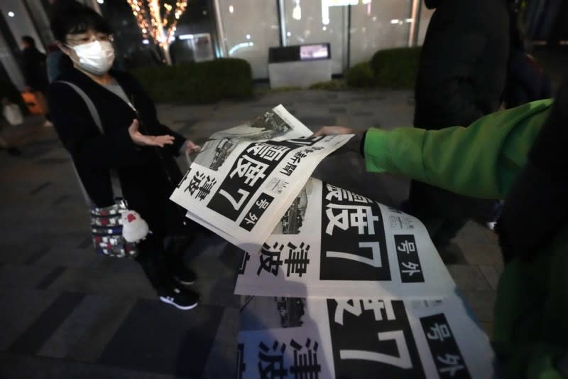 <cite>2024年1月1日，日本西部發生強震後，《讀賣新聞》在街頭發送快報。（美聯社）</cite>