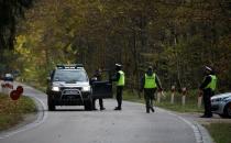 Polish police officers examine vehicles at a checkpoint on entry to the prohibited state of emergency zone, created to better manage an ongoing migrant crisis on the Belarusian-Polish border near Bialowieza