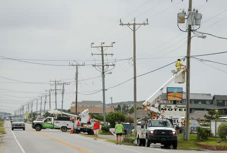 A worker from the local cable company works on the utility lines after Hurricane Arthur in Nags Head, North Carolina July 4, 2014. REUTERS/Chris Keane