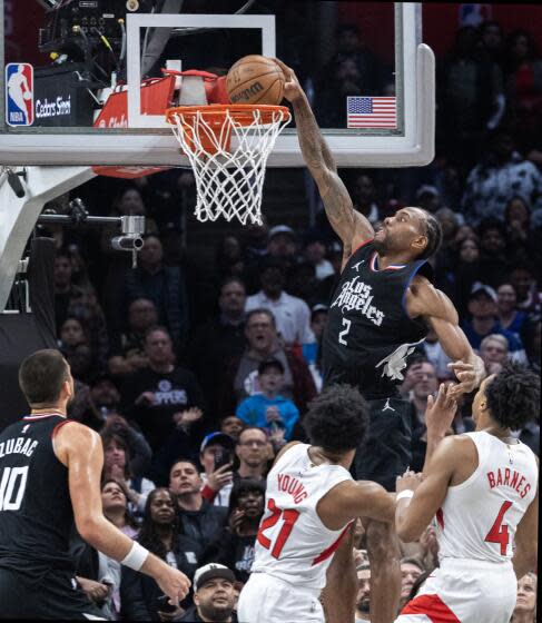 Clippers forward Kawhi Leonard dunks over Raptors forward Thaddeus Young (21) and Toronto Raptors forward Scottie Barnes (4).