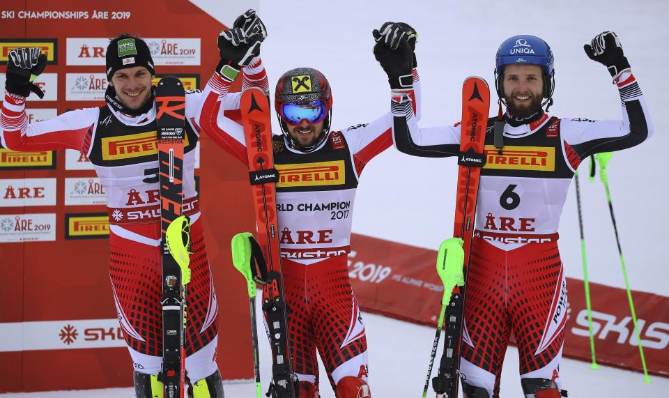 Austria's Marcel Hirscher, center, winner of the men's slalom, celebrates at the finish area with second-placed compatriot Michael Matt, left, and third-placed compatriot Marco Schwarz, at the alpine ski World Championships in Are, Sweden, Sunday, Feb. 17, 2019. (AP Photo/Marco Trovati)