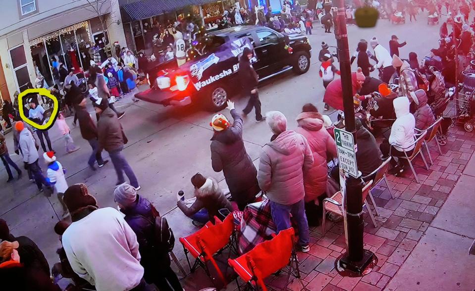 A video is show as Jeff Rogers, president of the Waukesha Blazers Youth Baseball Program is circled, who was walking in the parade with his children and baseball team, including 8-year-old Jackson Sparks who was killed in the parade, just before the SUV hits their team as he testifies as Darrell Brooks appears in a Waukesha County Circuit Court during his trial in Waukesha, Wis., on Tuesday, Oct. 11, 2022. Brooks, who is representing himself during the trial, is charged with driving into the Waukesha Christmas Parade last year, killing six people and injuring dozens more.