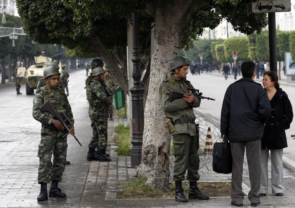 FILE - In this Tuesday Jan. 18. 2011 file photo, local residents speak with soldiers as they guard the center of Tunis. Tunisia’s president on Thursday March 6, 2014, lifted the state of emergency that has been in place since the outbreak of a popular revolution three years ago, and a top military chief said soldiers stationed in some of the country’s most sensitive areas will return to their barracks. (AP Photo/Christophe Ena, File)