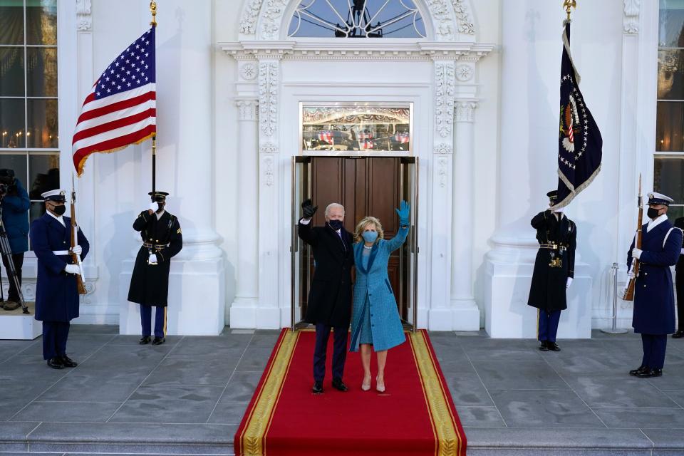 President Joe Biden and first lady Jill Biden wave as they arrive at the North Portico of the White House, Jan. 20, 2021.