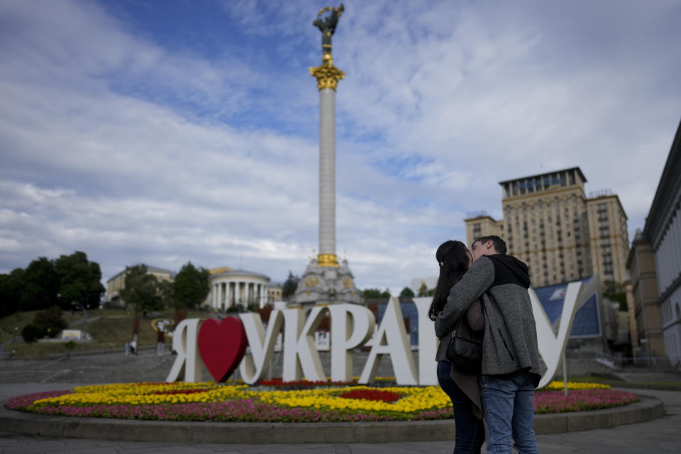 A couple kiss in downtown Kyiv, Ukraine, Wednesday, May 25, 2022. (AP Photo/Natacha Pisarenko)
