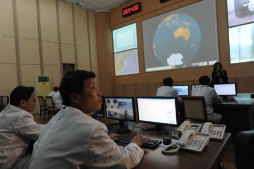 North Korean technicians work at the control room of the Tongchang-ri space center on April 8, 2012. The North insists its satellite launch was not banned under UN resolutions and did not breach a deal with the United States announced in February