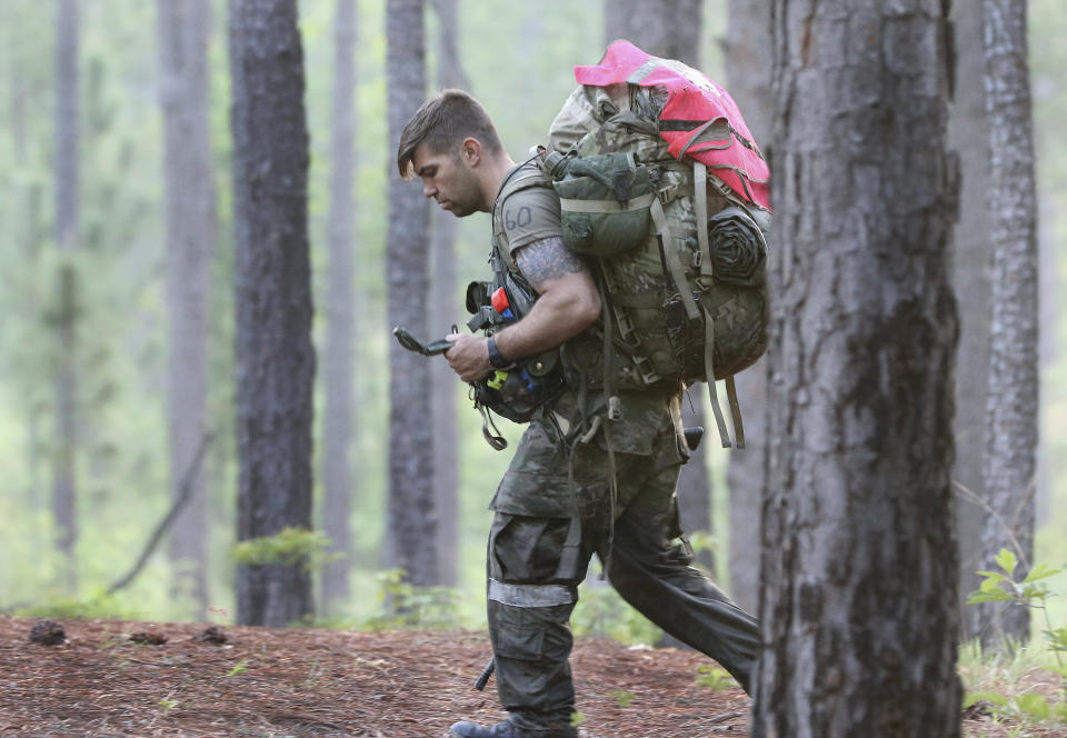 A soldier from the U.S. Army John F. Kennedy Special Warfare Center and School checks a compass while completing a land navigation course during Special Forces Assessment and Selection near Hoffman, N.C., May 7, 2019. U.S. special operations commanders are having to do more with less and they're learning from the war in Ukraine, That means juggling how to add more high-tech experts to their teams while still cutting their overall forces by about 5,000 troops over the next five years. (Ken Kassens/U.S. Army via AP)