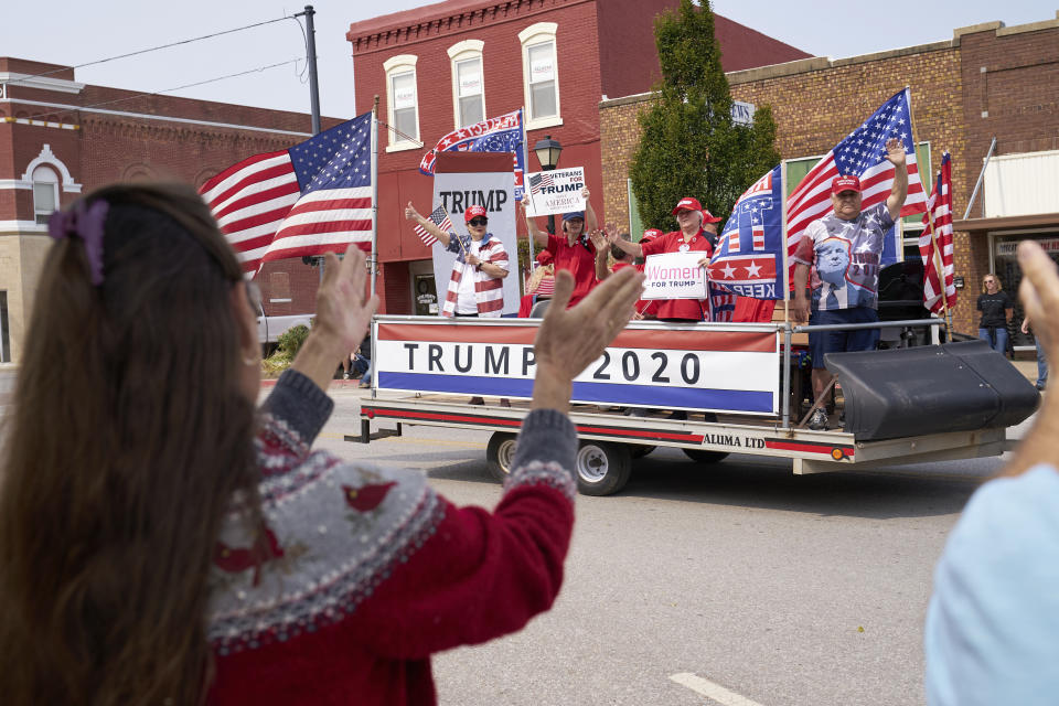 FILE-This Saturday, Sept. 19, 2020 file photo shows spectators applauding as a Trump 2020 float drives by during the annual Applejack parade in Nebraska City, Neb. Grassroots supporters for President Donald Trump have organized hundreds of boat, car and tractor parades across the nation to generate enthusiasm for his re-election campaign. Campaign strategists and analysts say the parades are a reflection of the president's populist appeal, but they have varying thoughts on whether they will impact the outcome. (AP Photo/Nati Harnik, File)