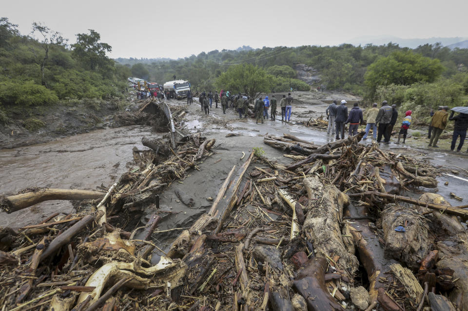 FILE — Passengers from stranded vehicles stand next to the debris from floodwaters, on the road from Kapenguria, in West Pokot county, in western Kenya Saturday, Nov. 23, 2019. Much of the world takes daily weather forecasts for granted. But most of Africa's 1.3 billion people live with little advance knowledge of what's to come. That can be deadly, with damage running in the billions of dollars. The first Africa Climate Summit opens this week in Kenya to highlight the continent that will suffer the most from climate change while contributing to it the least. At the heart of every issue on the agenda, from energy to agriculture, is the lack of data collection that drives decisions as basic as when to plant and when to flee. (AP Photo, File)