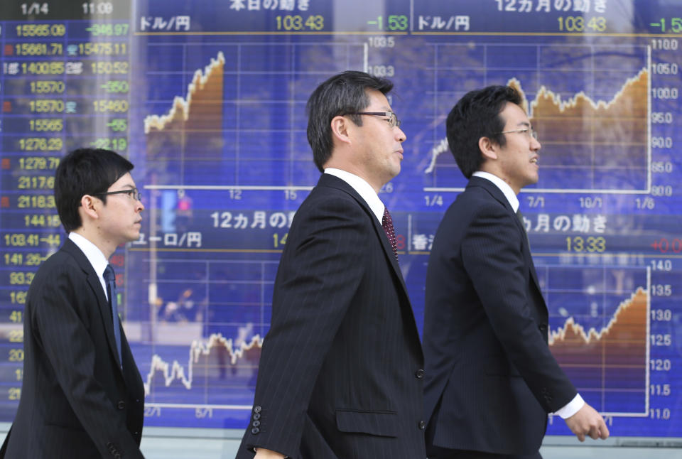 People walk by an electronic stock board of a securities firm in Tokyo, Tuesday, Jan. 14, 2014. Most Asian stock markets sank Tuesday, led by Japan, following a big sell-off in the U.S. (AP Photo/Koji Sasahara)