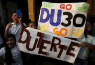 Supporters of presidential candidate Rodrigo "Digong" Duterte hold placards during election campaigning for May 2016 national elections in Malabon, Metro Manila in the Philippines April 27, 2016. REUTERS/Erik De Castro