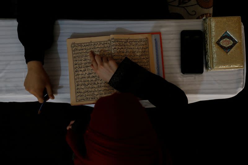 An Afghan girl reads the Koran in a madrasa or religious school in Kabul