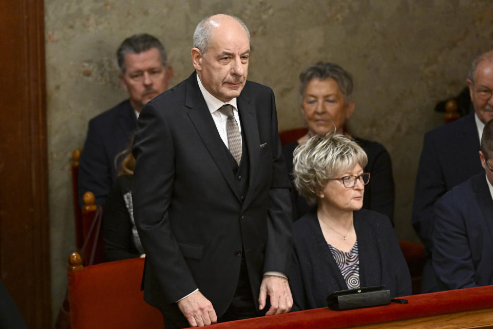 Tamas Sulyok, left, the head of Hungary's Constitutional Court, stands before a parliament vote to elect him as president, in Budapest, Hungary, Monday, Feb 26, 2024. Hungary's former president, Katalin Novak, stepped down in February, over a pardon she issued to an accomplice in a child sexual abuse case.(AP Photo/Denes Erdos)