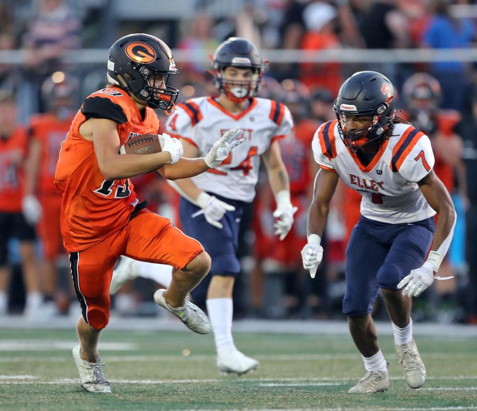 Green wide receiver Zachary Baglia cuts across the field against Ellet defensive back Timothy Peake after a reception Aug. 19, 2022, in Green.