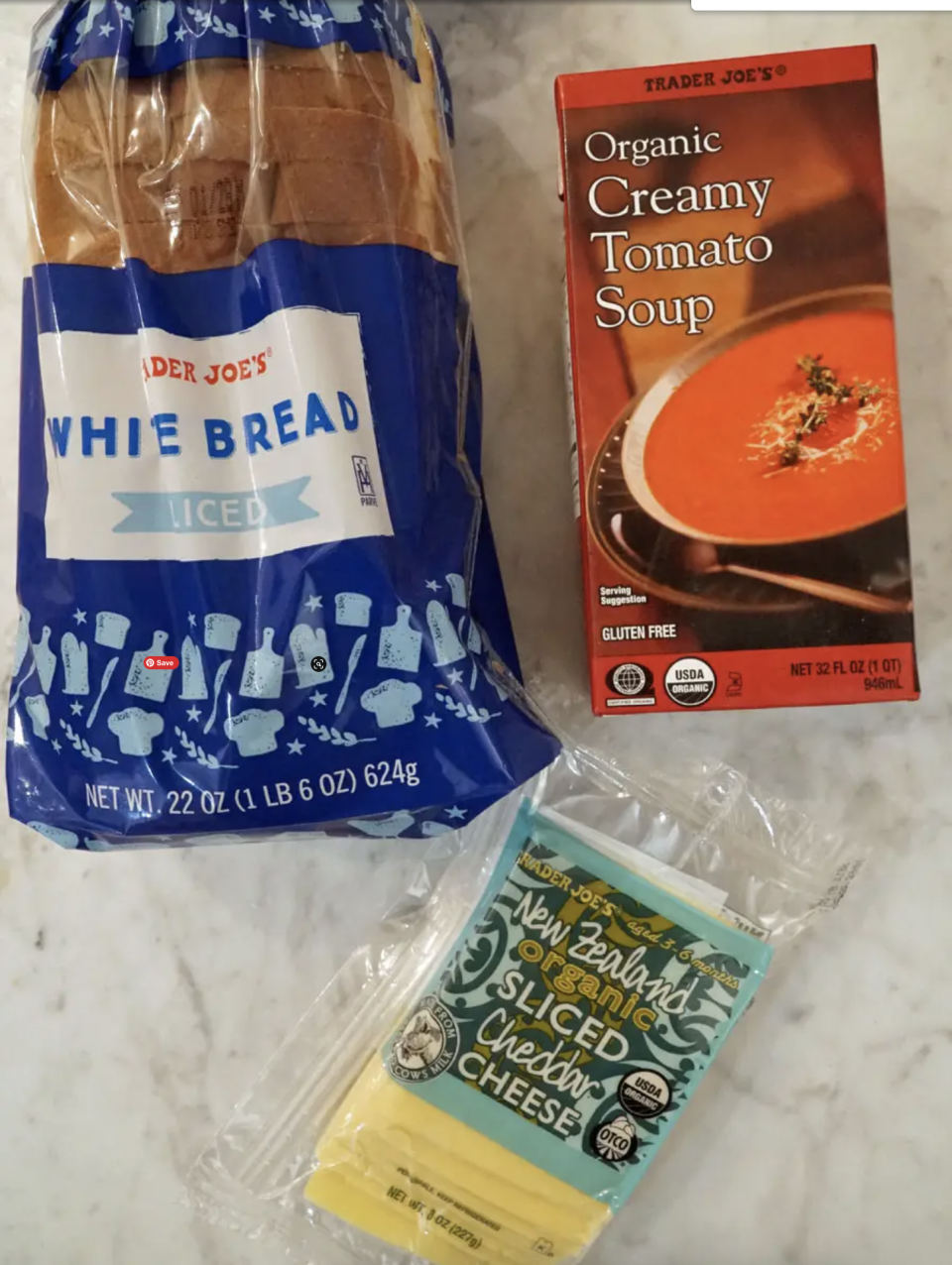 Trader Joe's containers of tomato soup, bread, and sliced cheddar cheese