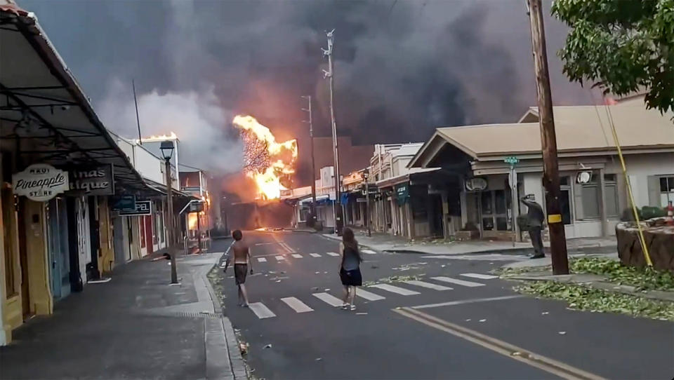 People watch the fire on Front Street in downtown Lahaina, Maui, Hawaii, on Aug. 8, 2023. (Alan Dickar via AP)