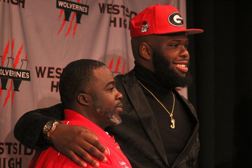 Westside High School defensive tackle Jordan Hall (right) stands alongside head football coach Randy Randall Jr. during his college football signing ceremony on December 22, 2022. [Clayton Freeman/Florida Times-Union]