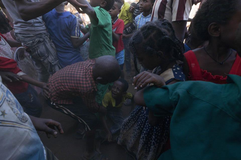Tigray refugee children fight over medical masks and sanitizer given out by Non Governmental Organization Maarif in front of a clinic run by Mercy Corps in Umm Rakouba refugee camp in Qadarif, Qadarif, eastern Sudan, Thursday, Dec. 10, 2020. (AP Photo/Nariman El-Mofty)