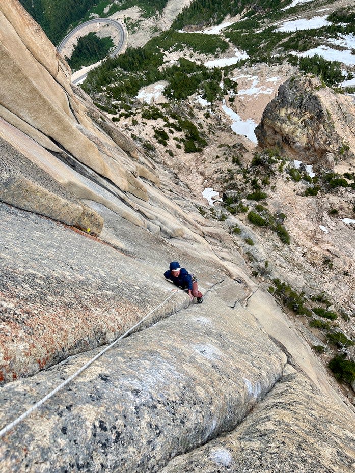 Rock climber high on cliff face in Washington Pass.