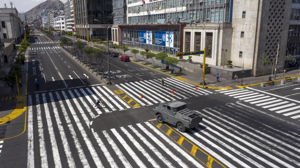 An armored vehicle guards an intersection on Abancay avenue, after the government implemented restrictions to prevent the spread of the new coronavirus in Lima, Peru, March 18, 2020. (AP Photo/Rodrigo Abd)