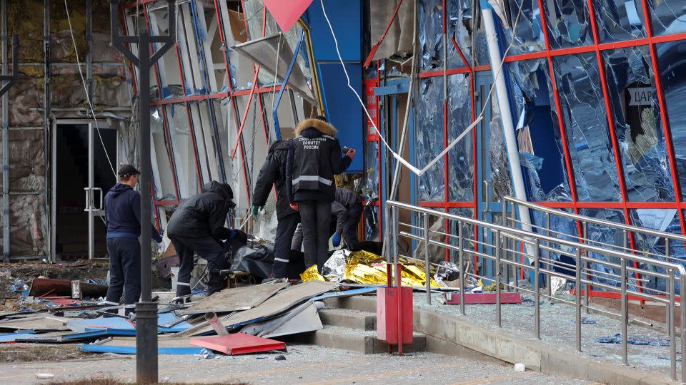 Specialists remove the body of a victim near a shopping center heavily damaged by a missile strike in what local authorities called a Ukrainian military attack, in Belgorod, Russia, on February 15, 2024. - Reuters