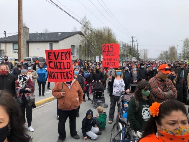 Signs at the Dene Nation memorial gathering march in Yellowknife on Friday read 'Every child matters' and '215 souls!!! We must never forget.'