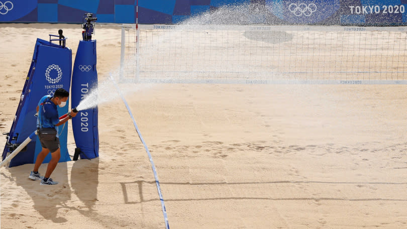沙灘排球場地的沙子實在太燙腳，讓選手無法忍受，東奧官方只能派人灑水幫沙子降溫。（圖／達志／路透社）