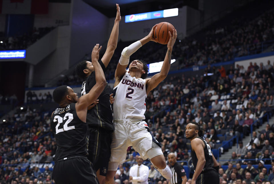 Connecticut's James Bouknight shoots over Central Florida's Darin Green Jr, left, and Central Florida's Frank Bertz, center, in the first half of an NCAA college basketball game, Wednesday, Feb. 26, 2020, in Hartford, Conn. (AP Photo/Jessica Hill)