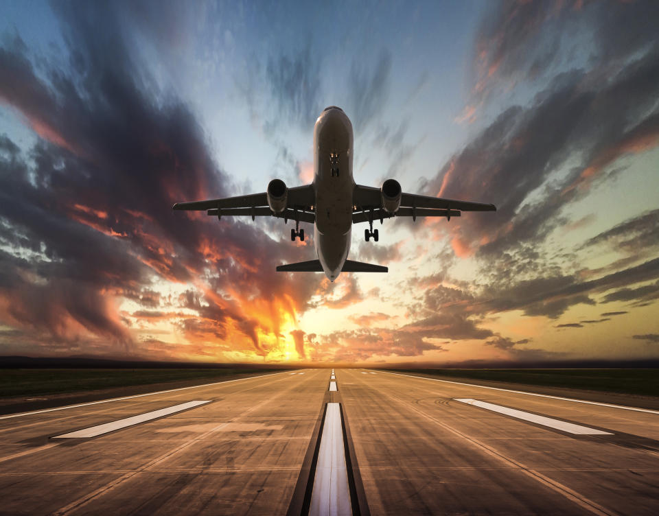 Passenger airplane taking off at sunset