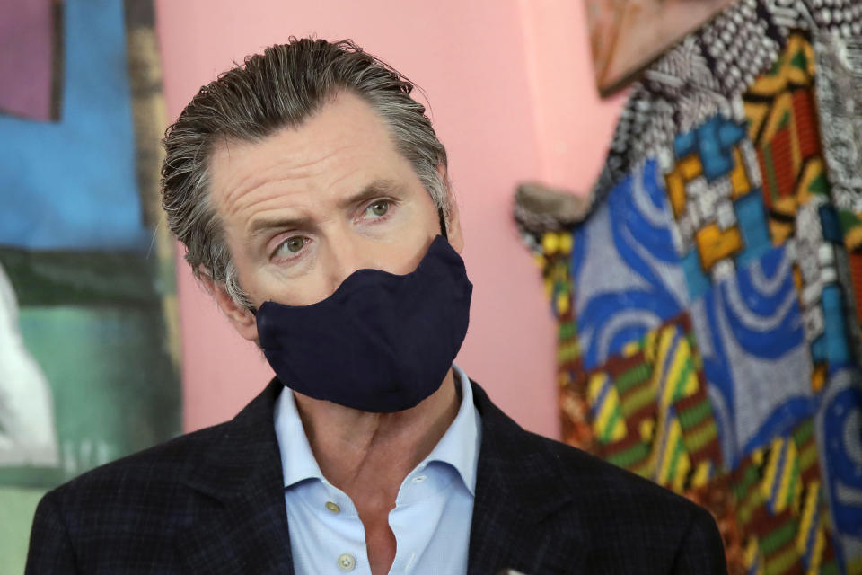 FILE - In this June 9, 2020, file photo, California Gov. Gavin Newsom wears a protective mask on his face while speaking to reporters at Miss Ollie's restaurant during the coronavirus outbreak in Oakland, Calif. Gov. Newsom's administration on Thursday, June 18, 2020, mandated that Californians wear masks in most indoor settings as the state continues to battle the coronavirus.(AP Photo/Jeff Chiu, Pool, File)